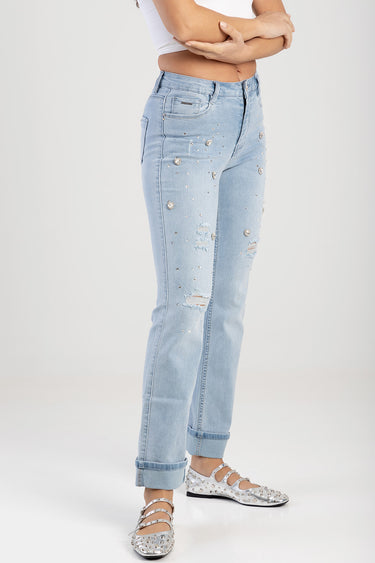 light blue distressed straight jeans with scattered silver studs and ripped patches, cuffs rolled, worn with a white top