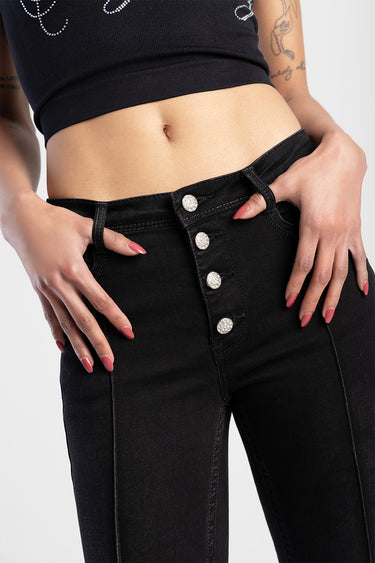 woman wearing black high waist jeans with silver button fly and cropped black top