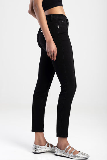 side view of a model wearing black skinny jeans with pockets and silver studded flats