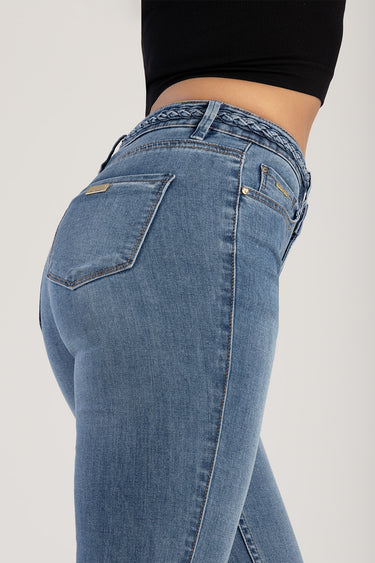 model wearing light blue denim jeans with a braided waistband, back pocket detail and gold hardware