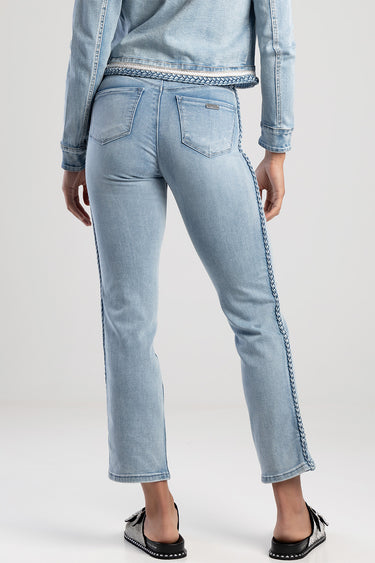 back view of a person wearing light wash straight jeans with braided trim along the outer seams and a woven belt, two back