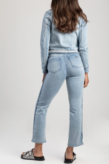 woman wearing light blue straight jeans by Blue Jean Traders with a braided belt, rear view shows back pockets and side