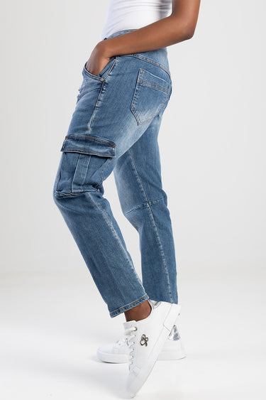 side view of a person wearing light blue cargo pants with multiple pockets and cuffed hems, white sneakers