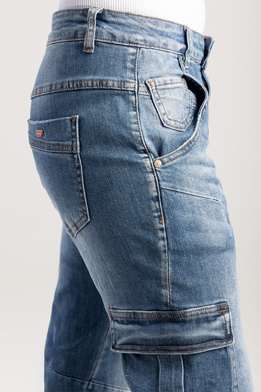 blue denim cargo pants on a model with belt loops and multiple pockets, including a large side cargo pocket.