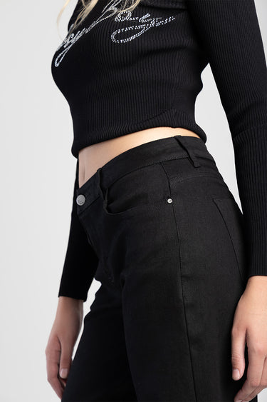 model wearing black wide leg jeans by blue jean traders with a cropped black knit top, side view
