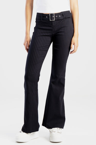 navy pinstripe trousers with a silver square belt buckle and belt loops, paired with white sneakers