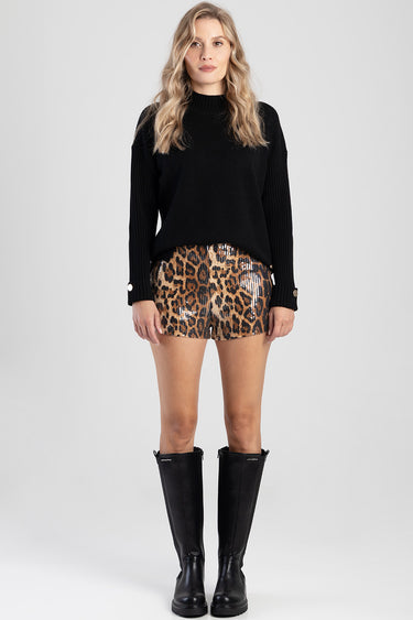 model wearing a black knit sweater and sequin leopard print shorts with tall black boots