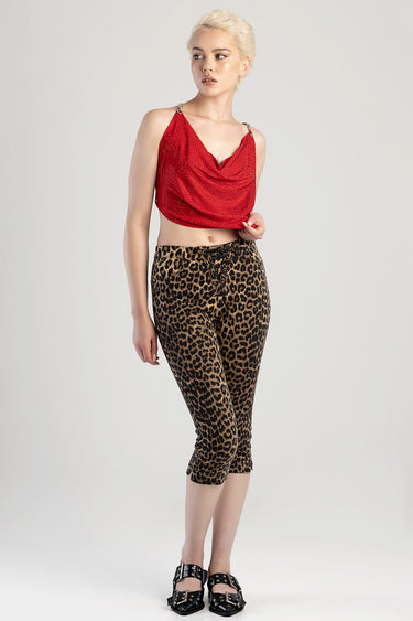 model wearing a red draped crop top and leopard print capri jeans with a lace-up waist