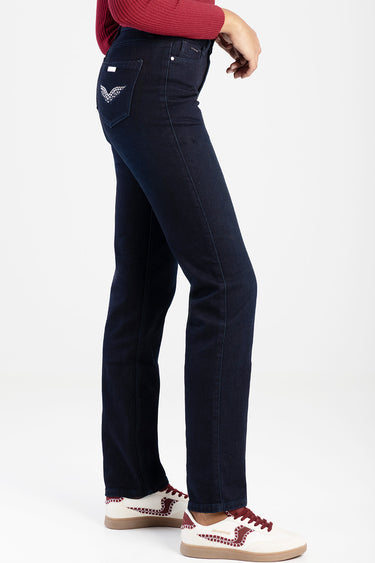 side view of dark blue straight jeans with a decorative back pocket logo, paired with a red top and white sneakers