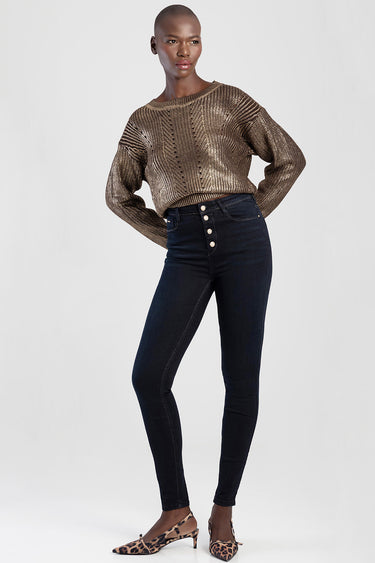model wearing blue jean traders skinny jeans with a high waist and button fly, paired with a metallic knit sweater and