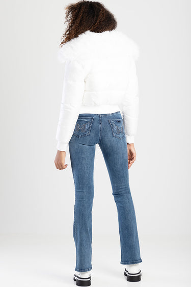 back view of a model in a white puffer jacket with fur trim wearing blue bootleg jeans with embroidered back pockets