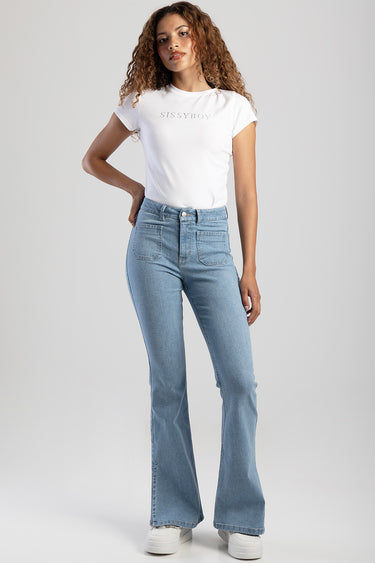 woman wearing a white tucked-in t-shirt and light blue high-rise flare jeans with white sneakers