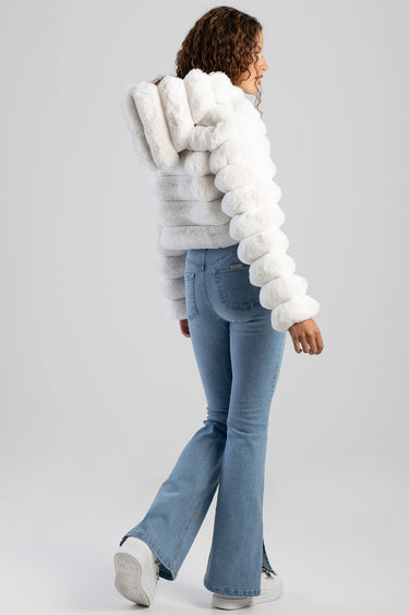 woman in a white fluffy jacket and blue skinny flare jeans back view