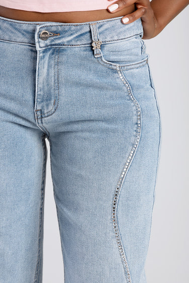 blue washed jeans by Blue Jean Traders at the waist with a metal button and chain trim along the front side seam
