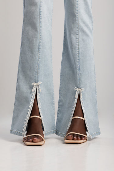 light blue bootcut jeans with white lace trim and small hem slits, worn with nude sandals