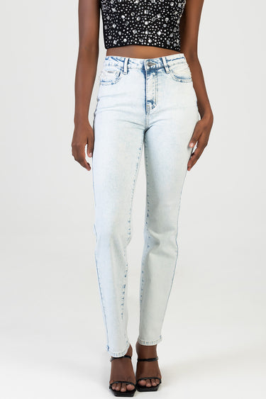 woman wearing light wash high waist stovepipe jeans with front pockets and a cropped black sequin top and black sandals