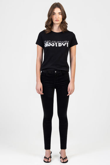 woman wearing black skinny pants and black t shirt with silver sequined graphic