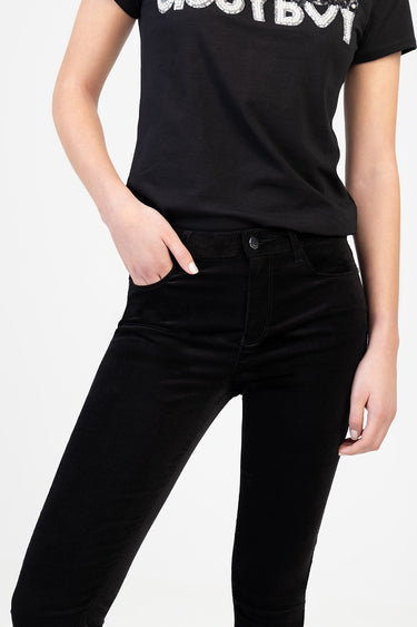woman wearing black skinny jeans and a black short sleeve top with silver glitter lettering