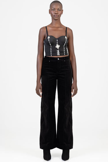 model wearing black wide leg pants with a black embroidered corset top featuring silver bead embellishments