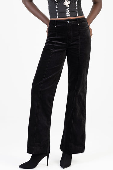 black wide leg pants by Blue Jean Traders on a model with front pockets and visible stitching, paired with black heeled boots