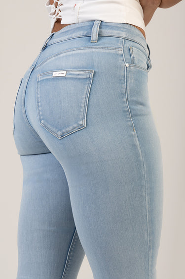 light blue skinny jeans viewed from the back with a single back pocket and a small brand patch