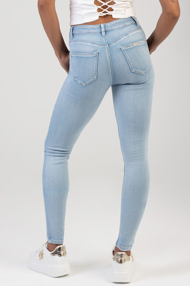 blue light wash skinny jeans from Blue Jean Traders, back view with patch pockets and white sneakers.