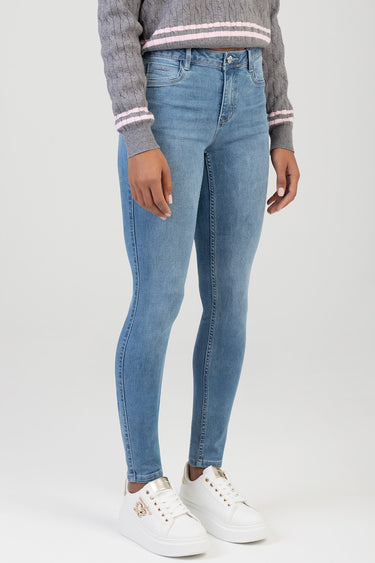 woman in light blue skinny jeans paired with a gray knit sweater and white platform sneakers