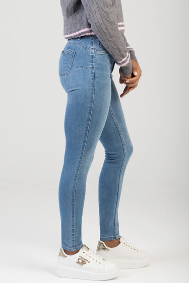 Blue Jean Traders blue skinny jeans worn by a model in a side pose with white platform sneakers
