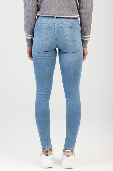 back view of a person wearing light blue skinny jeans by Blue Jean Traders with stitched back pockets and a small metal