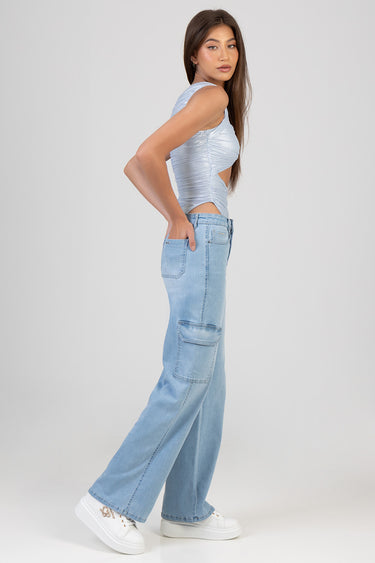 model in light wash wide leg jeans with cargo pockets, white sneakers, and a pale blue ruched sleeveless top, side profile