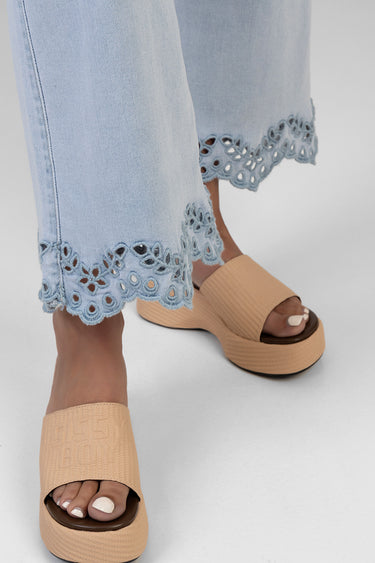 light wash cropped wide leg jeans with blue scalloped eyelet lace hem, paired with beige platform sandals