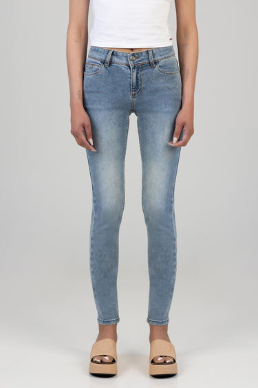woman wearing light blue skinny jeans with a white cropped top and beige platform sandals