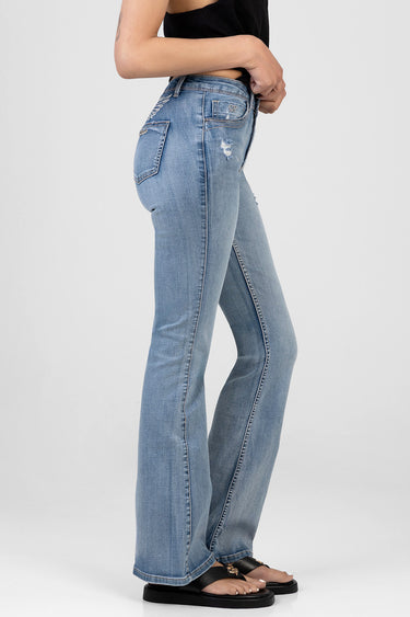 woman wearing light blue bootleg jeans with distressed details and back pockets and sandals