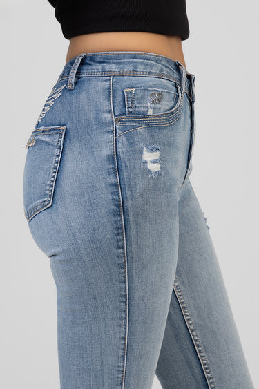 blue denim jeans close up showing back pocket with embroidered detail and distressed patch