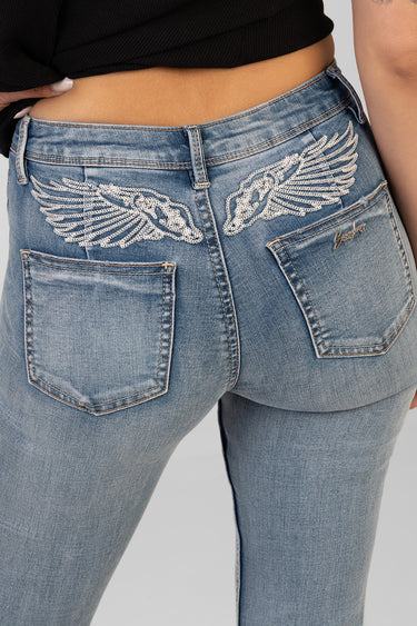 blue bootleg jeans with white wing embroidery on back pockets