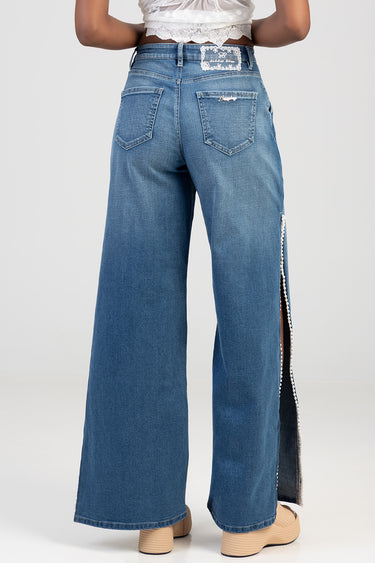 back view of blue wide leg jeans with a beaded side slit, two back pockets and belt loops