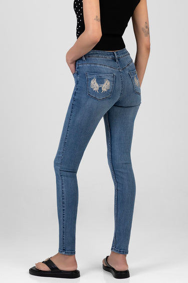 back view of blue skinny jeans with gold embroidered wings on the rear pockets