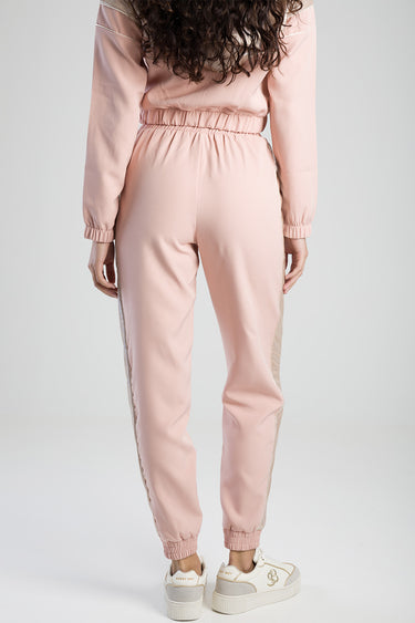 back view of pink tracksuit pants with a beige side stripe and gathered cuffs