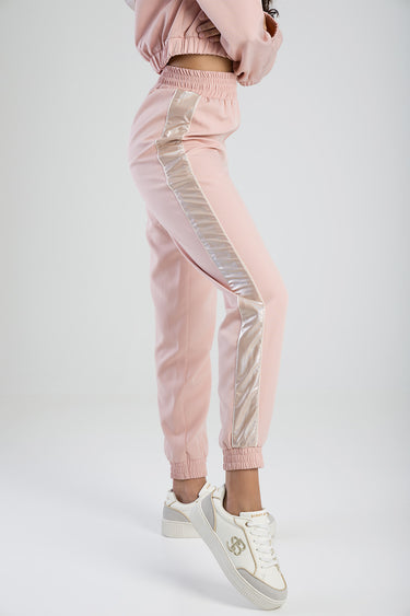 pink tracksuit pants with a silver metallic side stripe, elastic waist and cuffs, worn with white sneakers