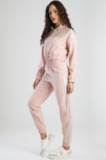 woman wearing pink tracksuit pants with light beige side panels and elastic cuffs