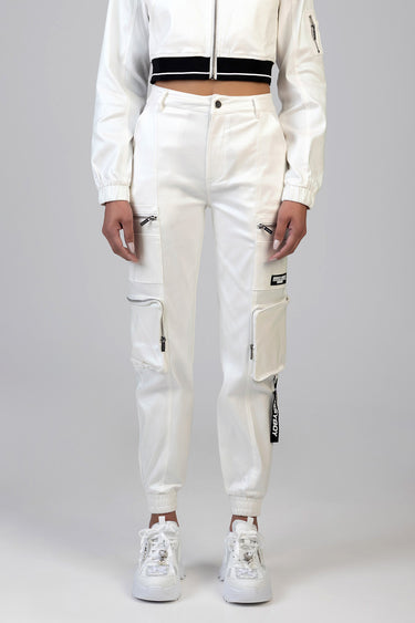 woman in white cargo pants with zip pockets and ankle cuffs, paired with a cropped white jacket and white sneakers