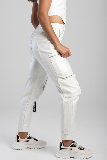 side view of a person in white cargo pants with zip pockets and elastic cuffs, wearing sneakers