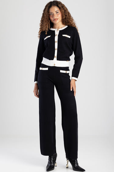 woman wearing navy knit pants with white trim cardigan featuring gold buttons and front pockets