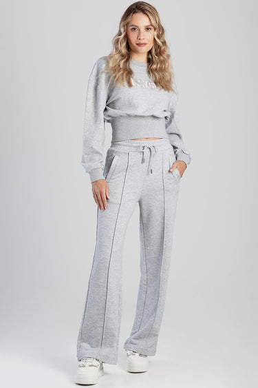woman in light grey knit joggers with a drawstring waist and a matching cropped sweatshirt