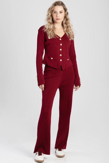 woman in burgundy ribbed knit cardigan and matching flared pants with gold buttons and white sneakers