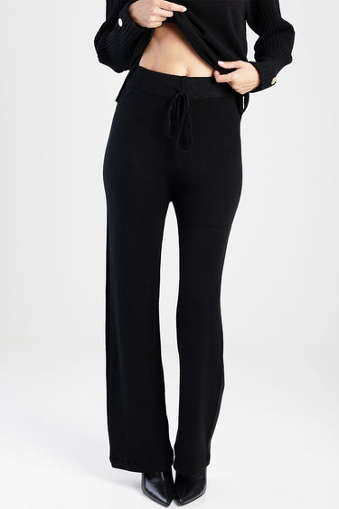 black knit pants with drawstring waist, full length, on a model wearing a black top.