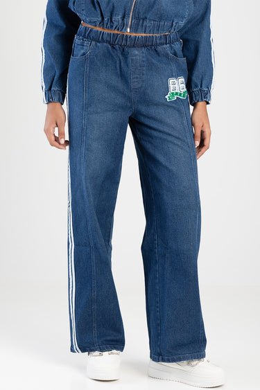 Blue Jean Traders track jeans with white side stripes and a small patch on the left hip, shown with a matching blue jacket