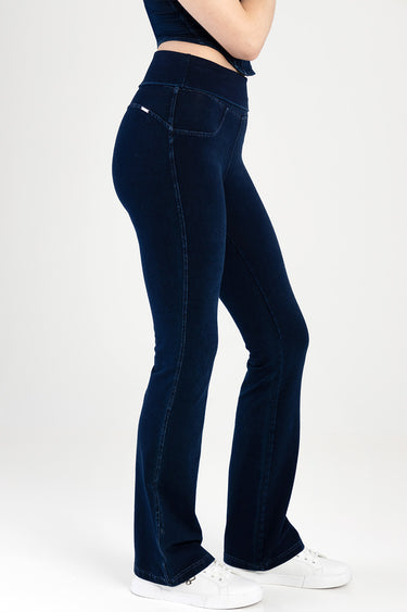 Blue Jean Traders side view of a person in dark indigo flare jeans and white sneakers