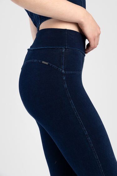 model wearing navy blue high waist flare jeans, close view of back pocket and seam details