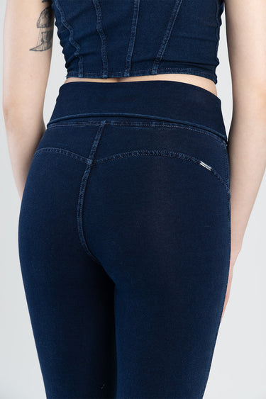 back view of dark blue jeans with a high waistband, visible curved seams, and a small white tag on the pocket